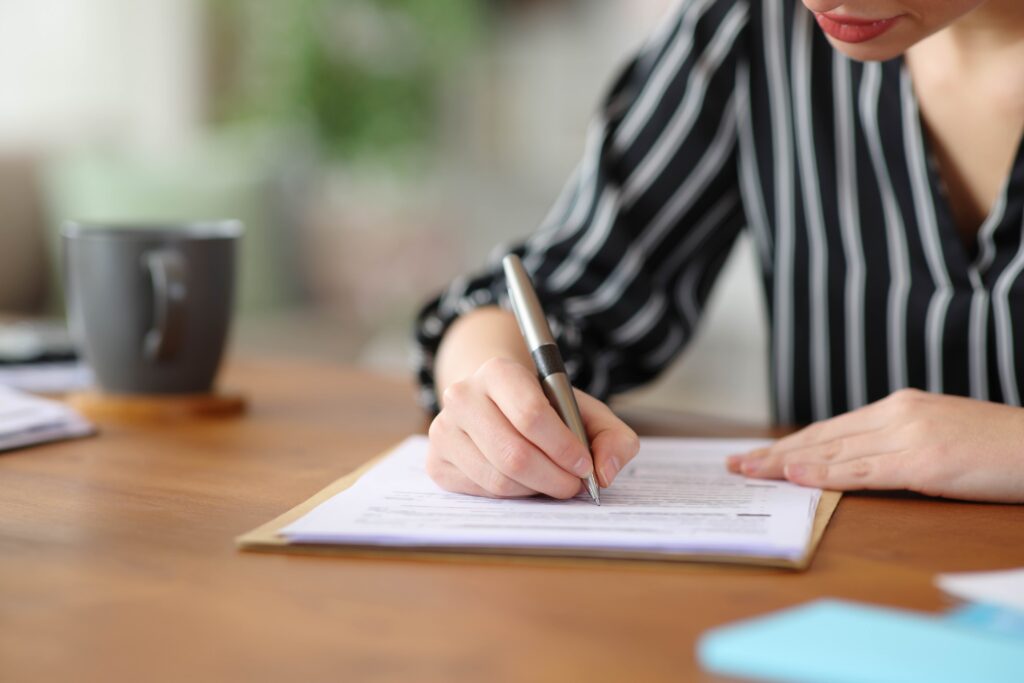 Close up of a person writing and working on grant tracking