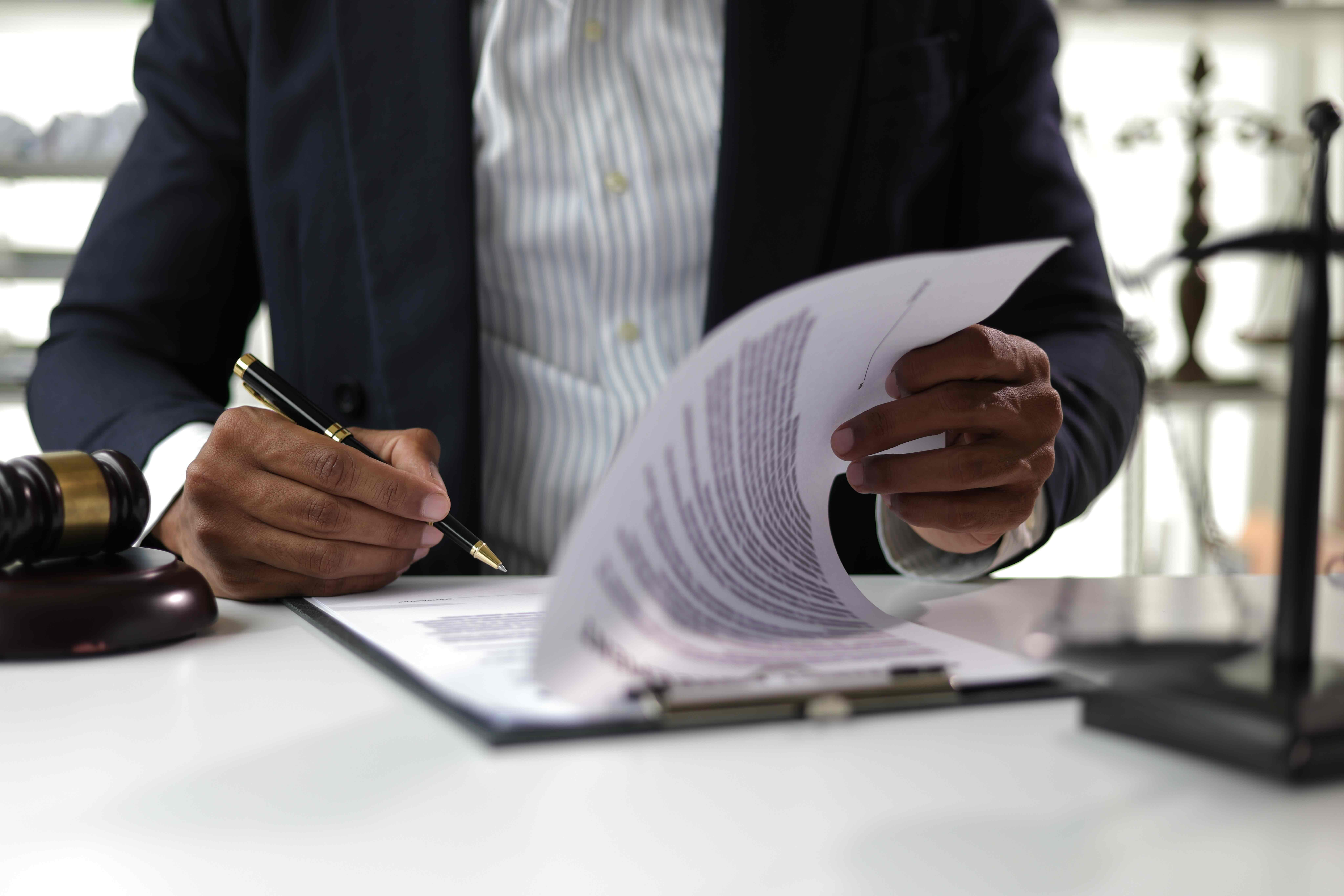 Legal professional reviewing earmarks government funding paperwork at a desk with a gavel nearby